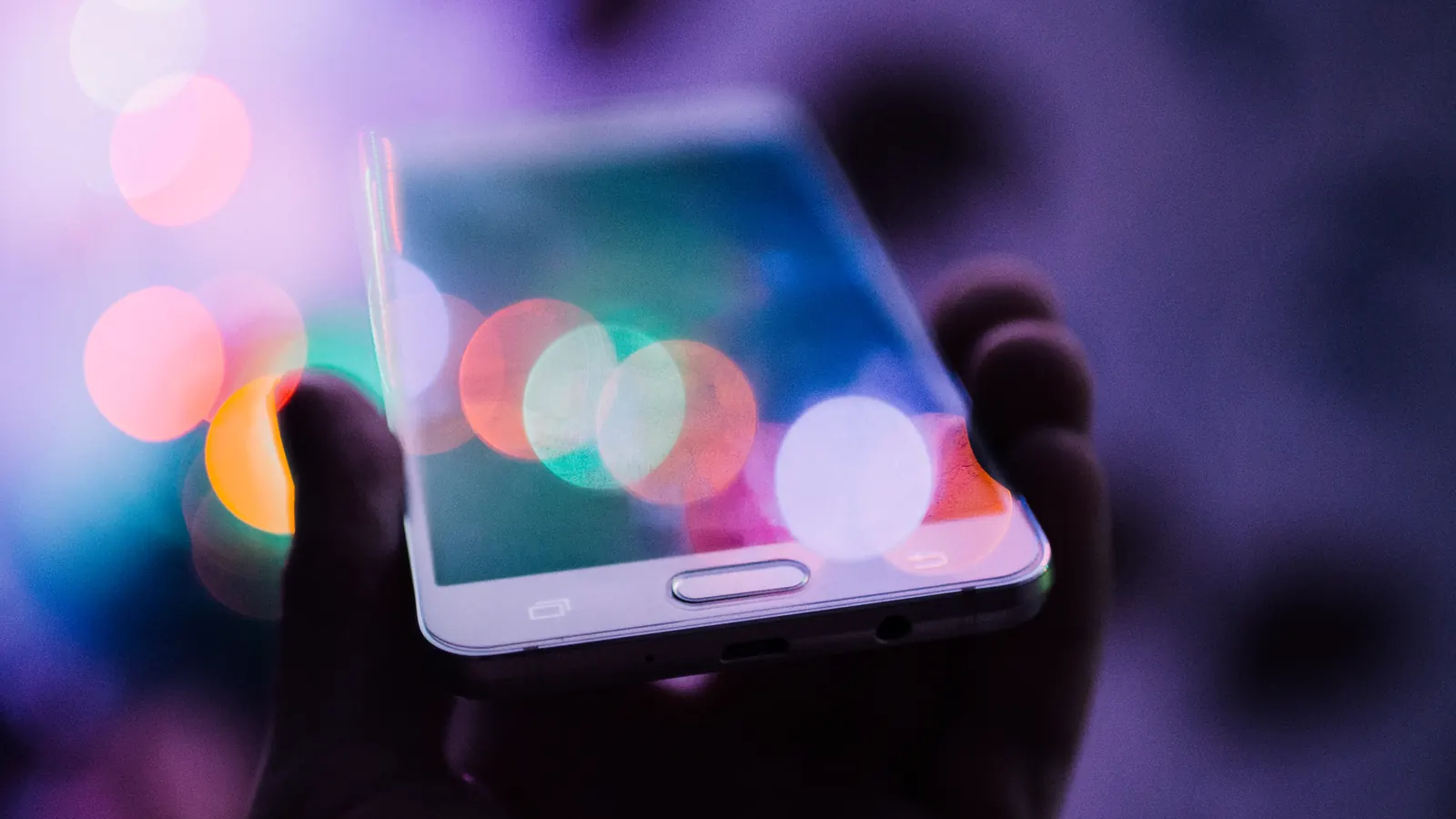 Un celular entre luces de colores desenfocadas