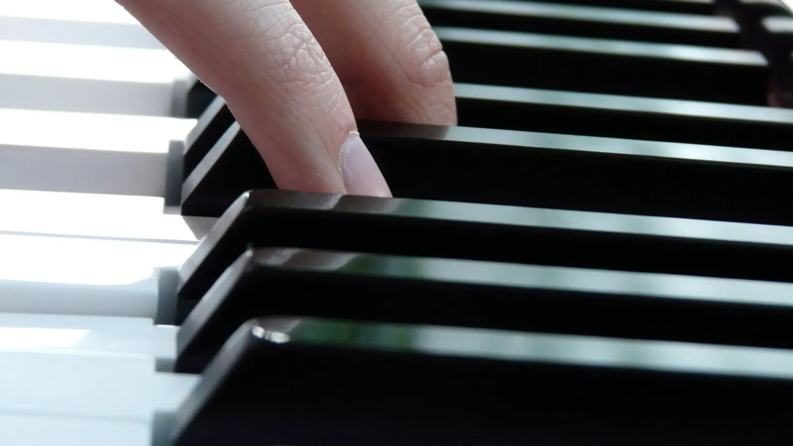Dedos sobre las teclas blancas y negras de un piano